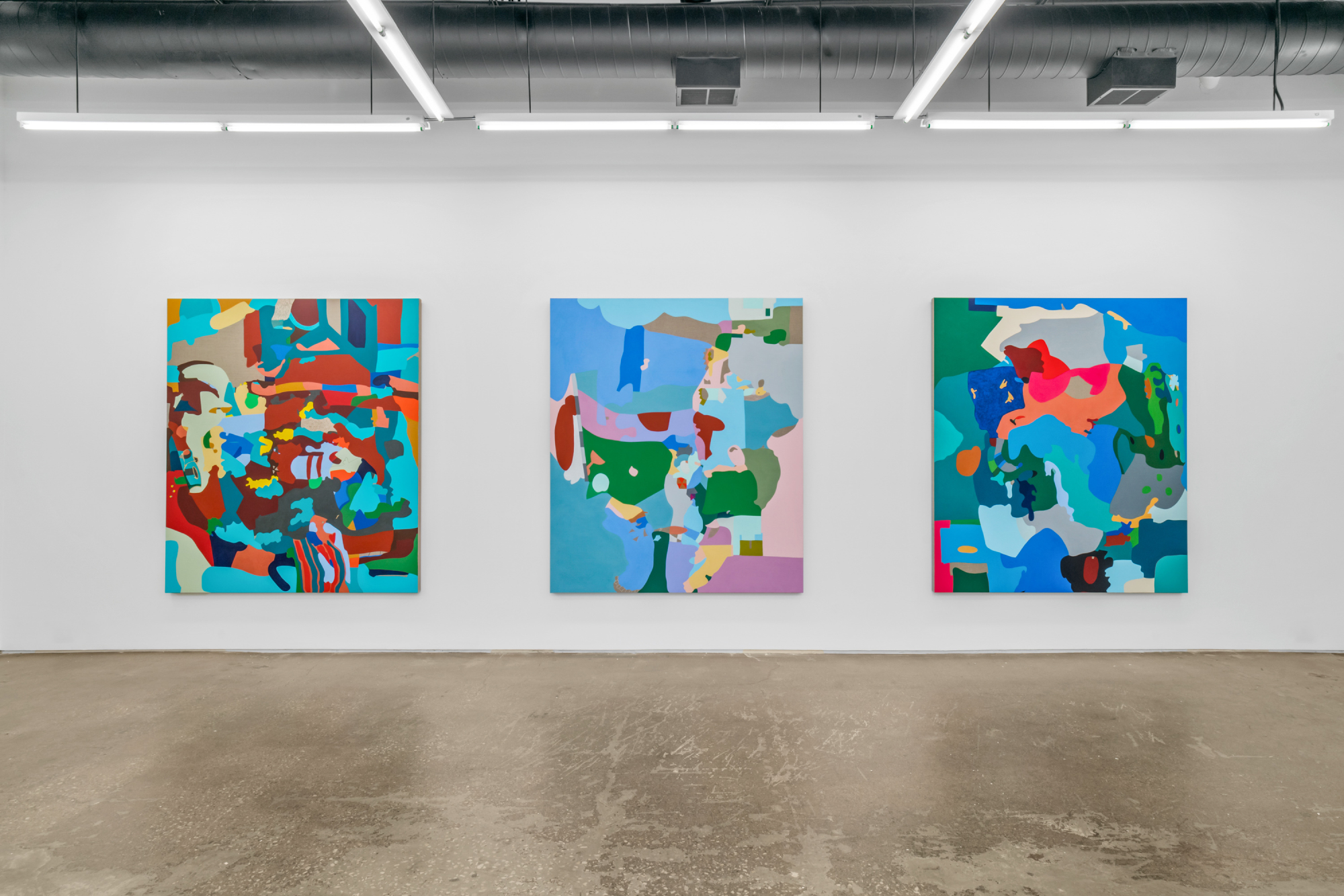Three abstract multicolored paintings hanging side by side at Monique Meloche Gallery.