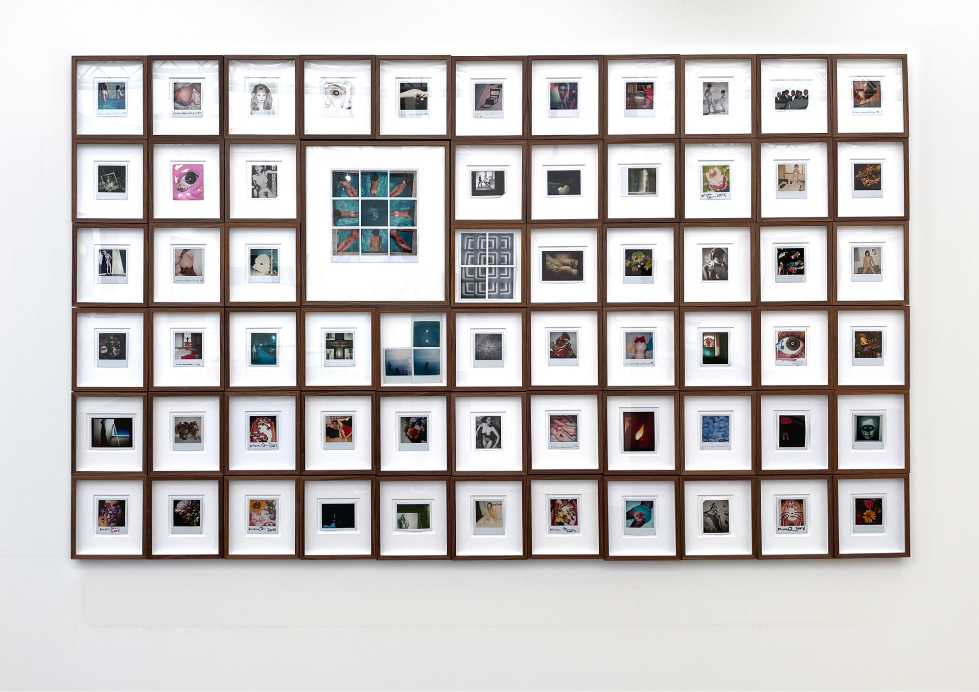 Framed photographs displayed on a white wall at The Association of International Photography Art Dealers (AIPAD)